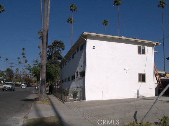 Front view of a two-story building with white exterior walls and windows.
