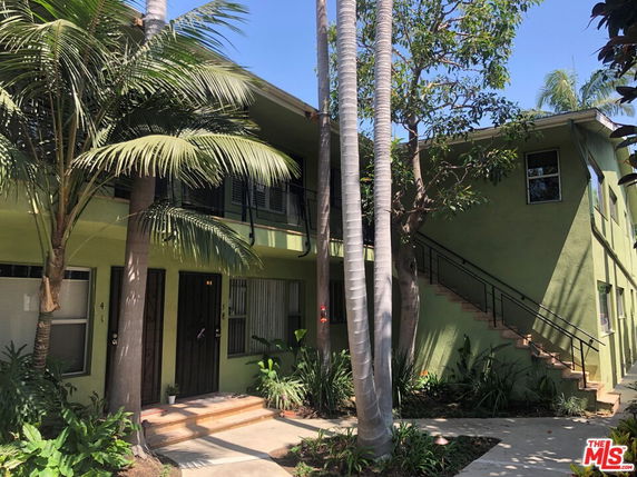 Front view of a two-story residential building with external staircases.