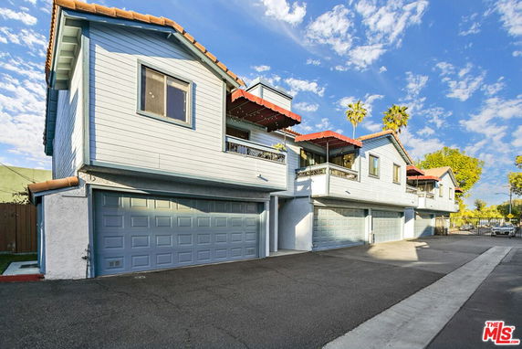 Front view of a two-story building with multiple garages and balconies.