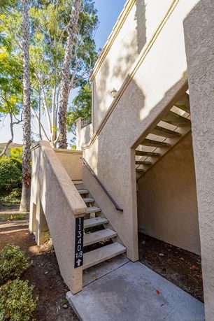 Exterior view of a residential building with outdoor stairs leading to a second level.