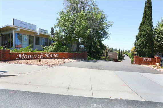 Front view of a building with a sign reading 'Monarch Manor.'