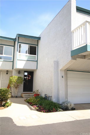 Front view of a multi-story house with a garage and entry pathway.