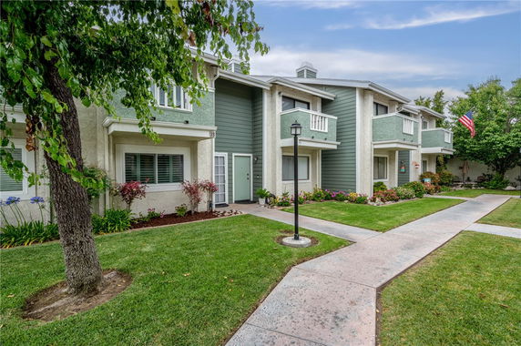 Front view of a two-story apartment building with balconies and green paneling.
