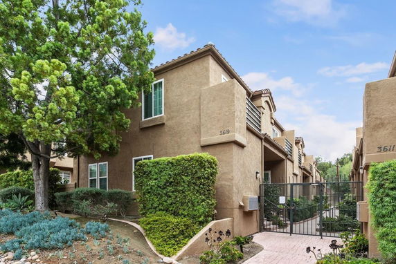 Front view of a multi-story residential building with a gated entrance.