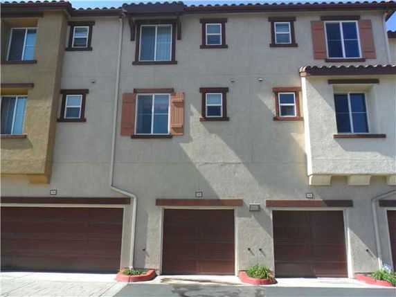 Front view of a multi-story residential building with multiple garages.