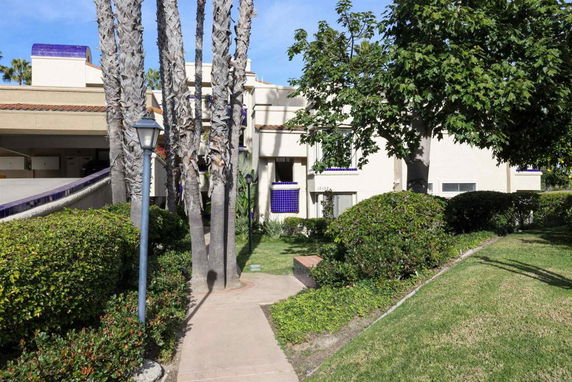 Front view of a modern building with multiple levels and a ramp entrance.