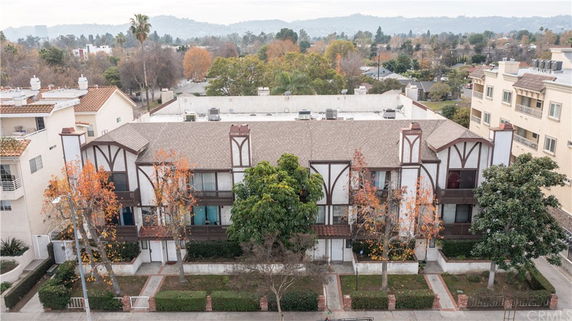 Multi-story residential building with a Tudor-style facade and surrounding landscape.