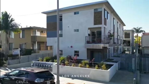Front view of a modern multi-story building with balconies.