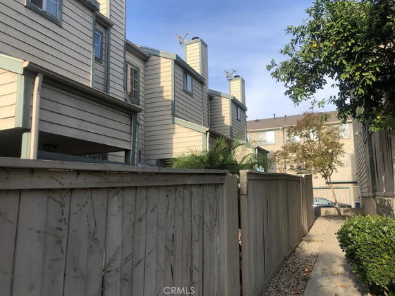 Rear view of multi-story residential buildings with wooden fences.