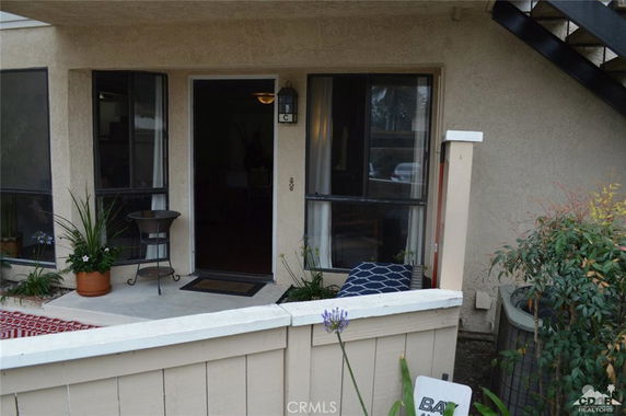 Front view of an apartment unit with a small patio and entrance.