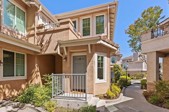Front view of a two-story house with a small balcony and entryway.
