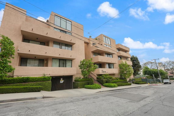 Front view of a multi-story apartment building with large balconies.