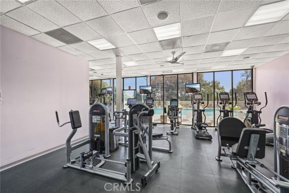 Interior view of a gym area with various exercise machines and large windows.
