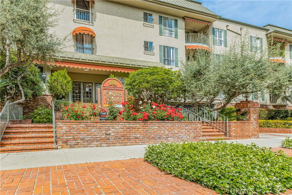 Front view of a multi-story building with balconies and orange awnings.