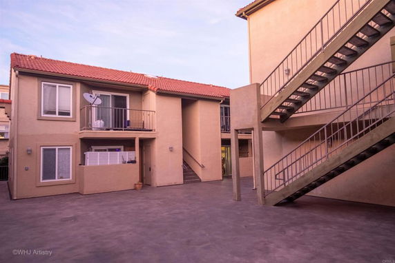 Front view of a two-story building with external staircases and balconies.