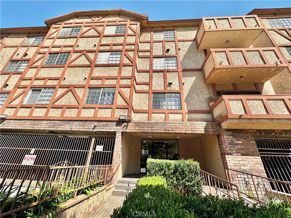 Front view of a multi-story building with brick and plaster facade.