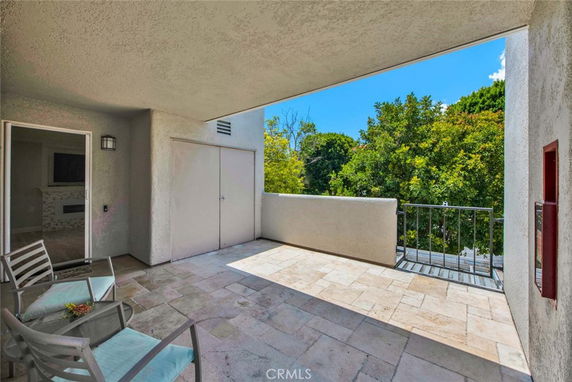 Balcony area with tiled floor overlooking trees