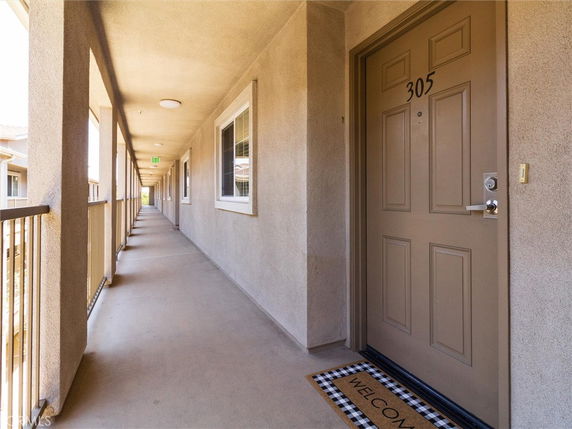 Exterior corridor of a building with door number 305.