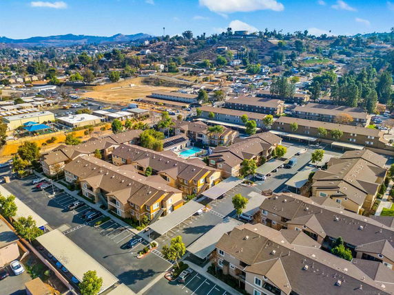 Aerial view of a residential complex with multiple buildings and a swimming pool.