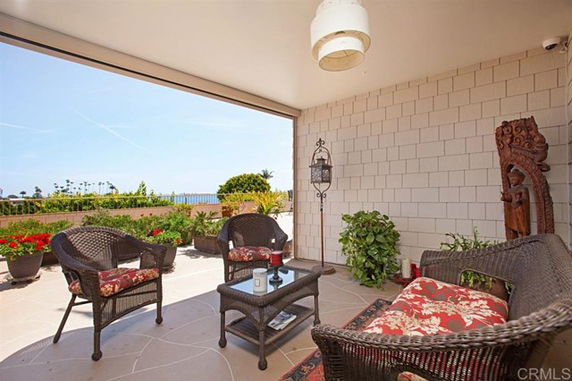 Outdoor patio area with wicker furniture overlooking a scenic view.