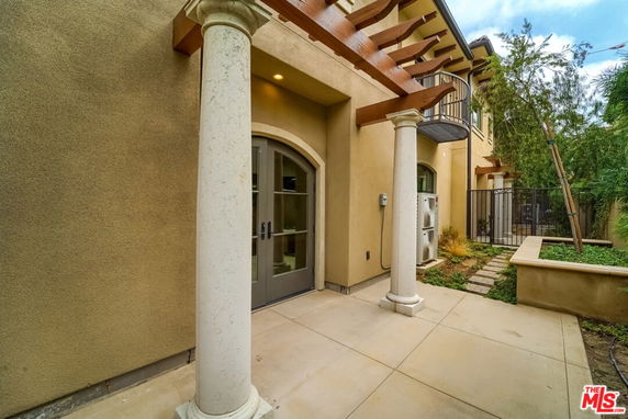 Front view of a house with columns and a balcony.