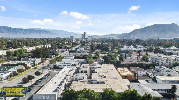 Aerial view of a cityscape with buildings and mountains in the background.