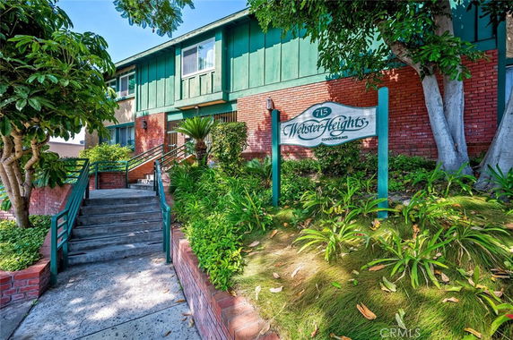 Front view of a two-story condominium building with green and red brick exterior.