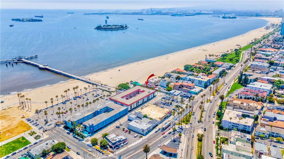 Aerial view of a coastal city with beach, pier, and ocean.