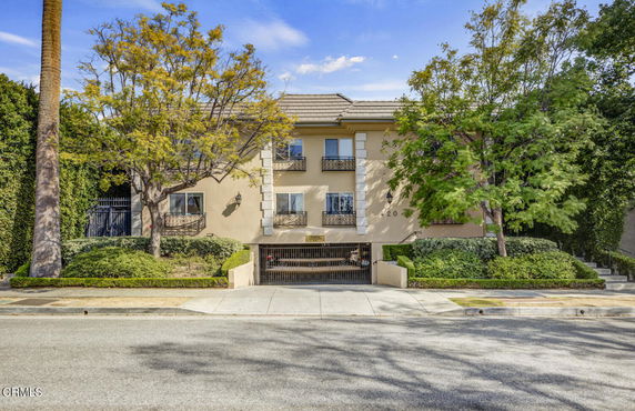 Front view of a multi-story residential building with gated entrance.