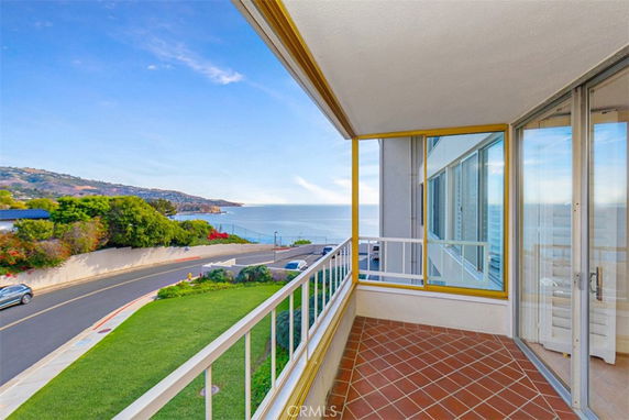 View from a balcony overlooking the ocean and coastal landscape.
