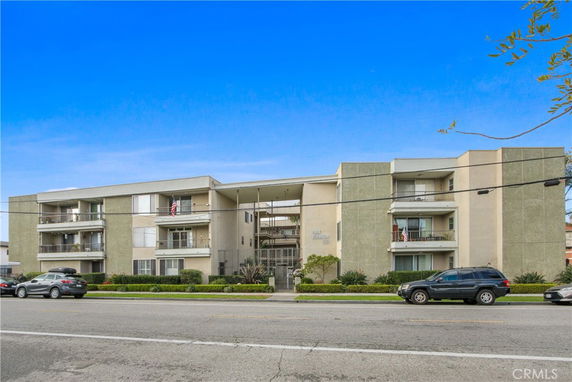 Front view of a multi-story apartment building with balconies.