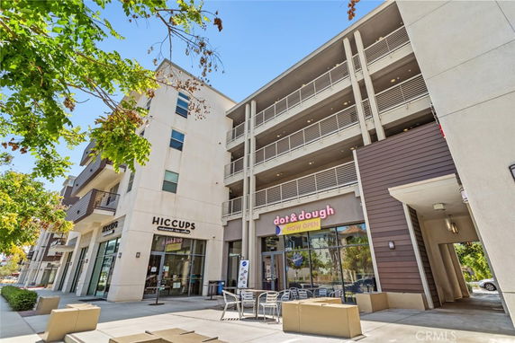 Front view of a multi-story commercial building with shops on the ground floor.