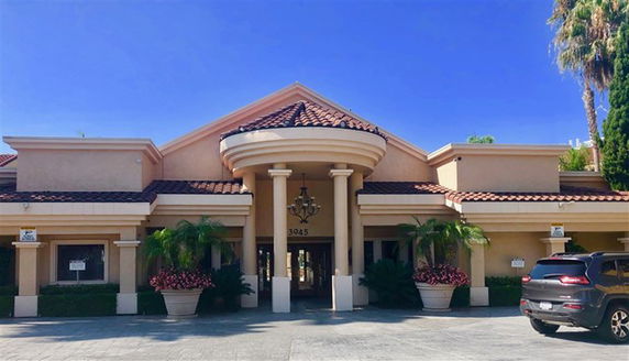 Front view of a building with a columned entrance and a tiled roof.