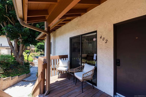 View of a small porch area with seating, adjacent to a building entrance.