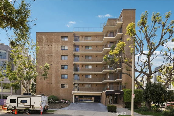 Front view of a multi-story apartment building with balconies.
