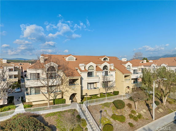 Front view of a multi-story apartment building with balconies and arched windows.