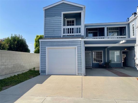 Front view of a two-story house with a garage and balcony.