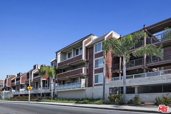 Front view of a multi-story apartment building with balconies.