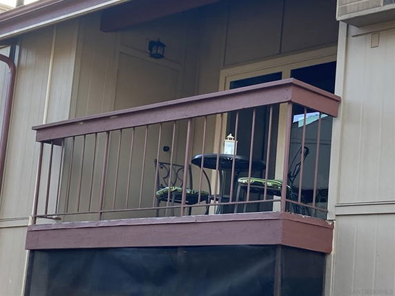 A balcony with railing and patio furniture on a residential building.