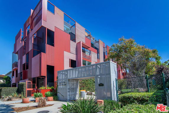 Front view of a modern multi-story building with a unique red and white facade.