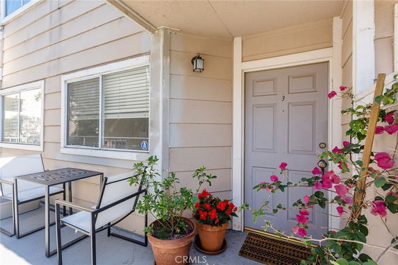 Front view of an entrance to an apartment with a small patio area.