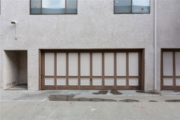 Front view of a building with a garage door and upper floor windows