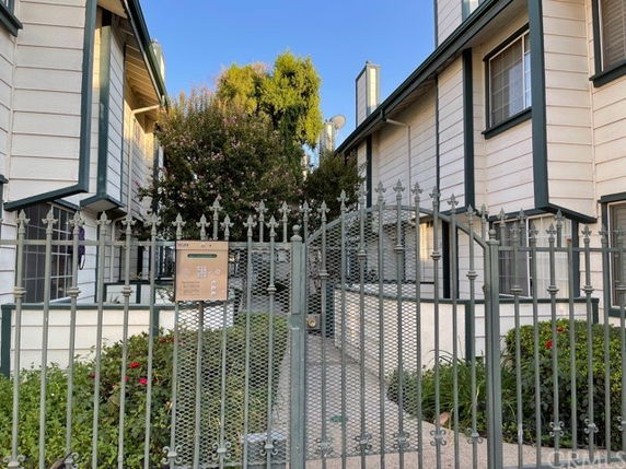 Front view of a gated residential building with adjacent structures.