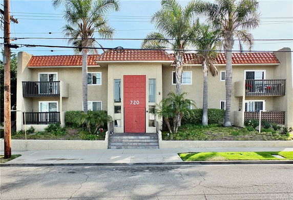 Front view of a two-story building with balconies and a red-tiled roof.