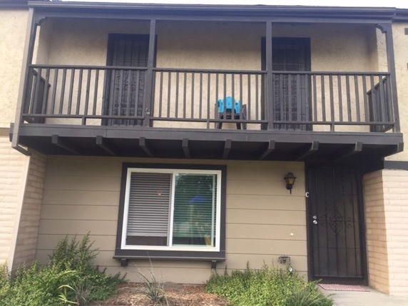 Front view of a two-story house with a balcony and single front door.
