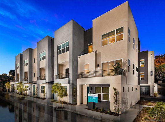 Front view of modern multi-story townhouses with large windows and balconies.