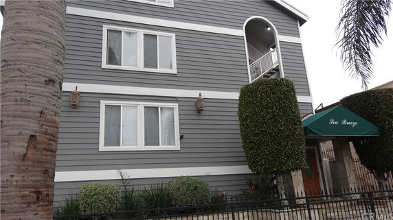 Front view of a multi-story house with gray siding and white trim.