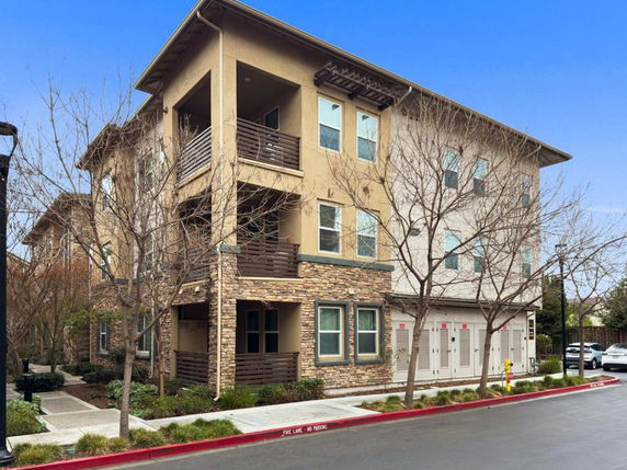 Front view of a three-story apartment building with balconies.