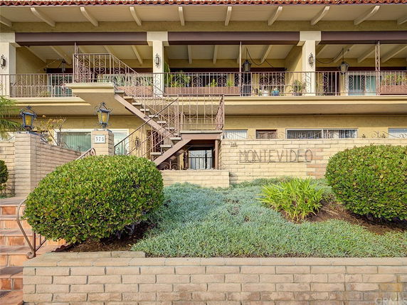 Front view of a multi-story building with decorative metal railings and a staircase.