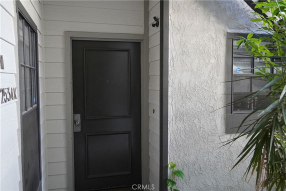 Front view of a house with a dark colored door and adjacent windows.